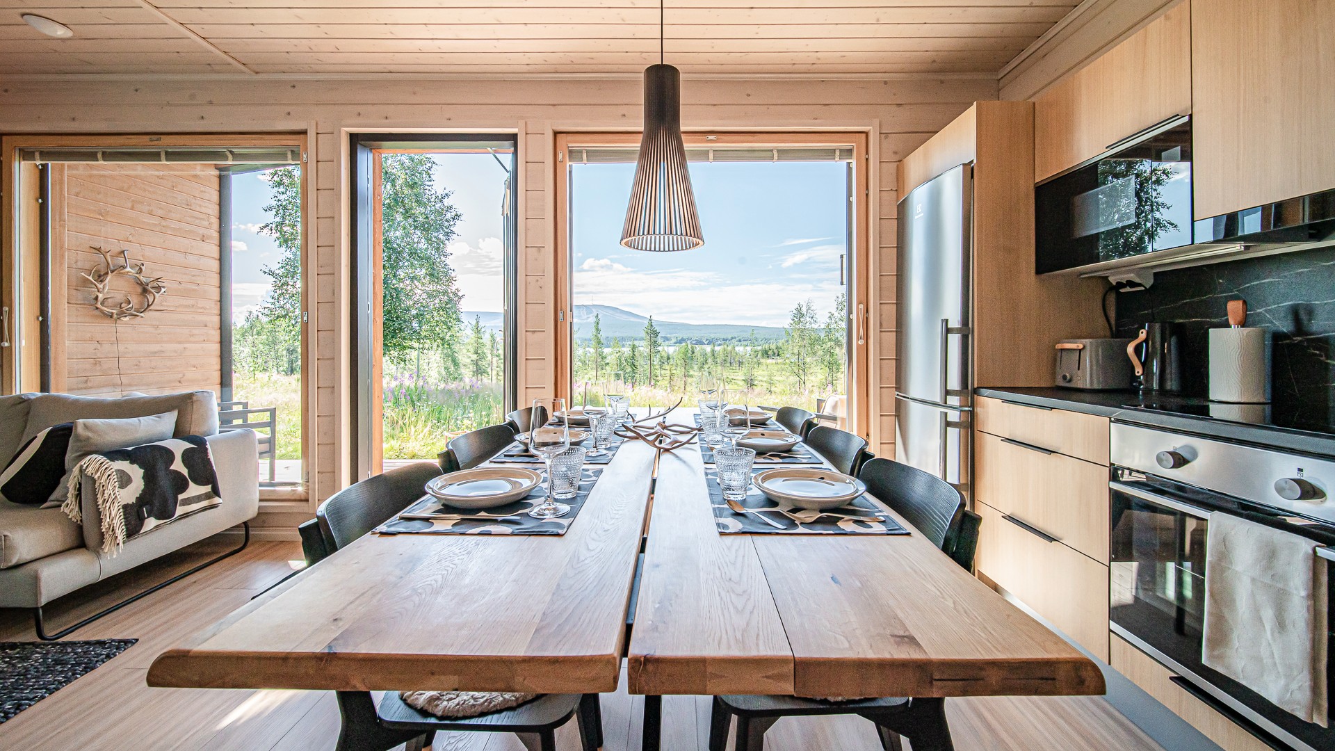 A wooden dining table with a summer fell landscape in the background
