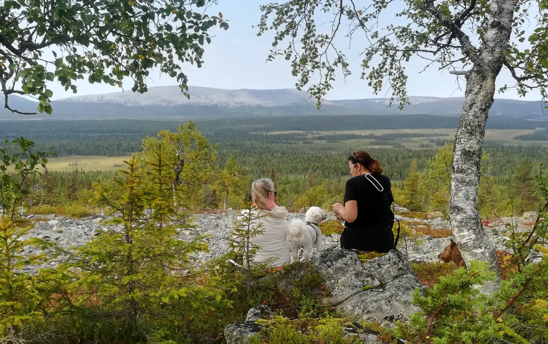 Two women having a break and sitting watching the fell view in Totovaara, Haavepalo.