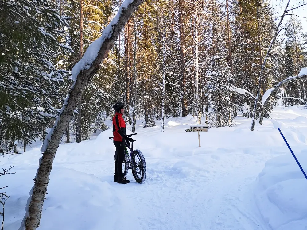 fatbiking A man standing with a fatbike in a snowy forest in Ylläs