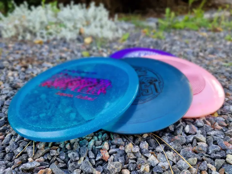 frisbeegolf A stack of colorful frisbee discs against a rocky path.