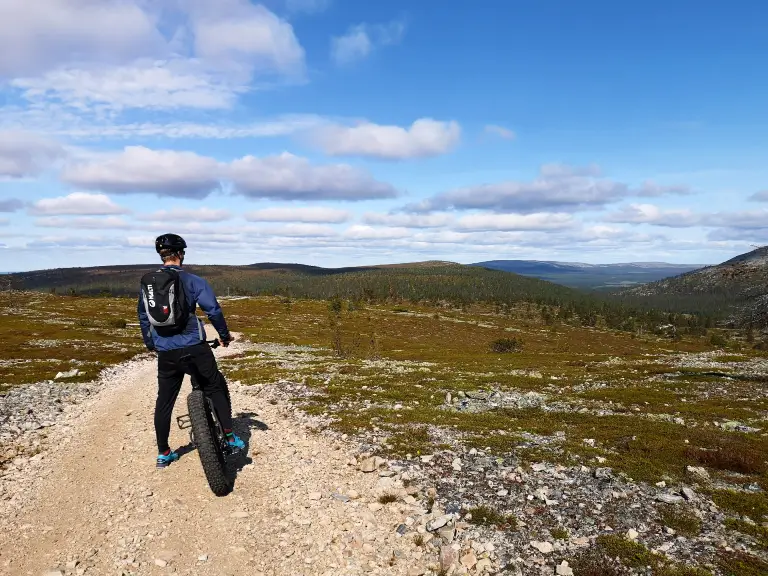 yllas_bike_3 A man with a bike watching a beautiful scenery on top of a fell in Ylläs.