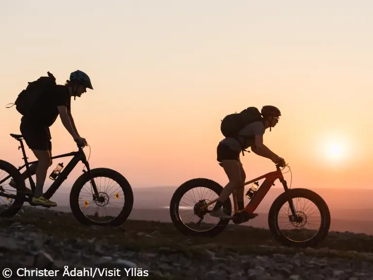 biking_yllas Two mountain bikers going down the Ylläs fell in sunset.