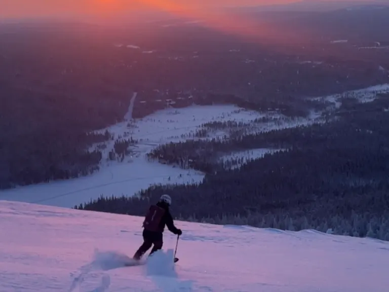 yllas alpine skiing A man with a downhill gear watching sunset on top of Fell Ylläs