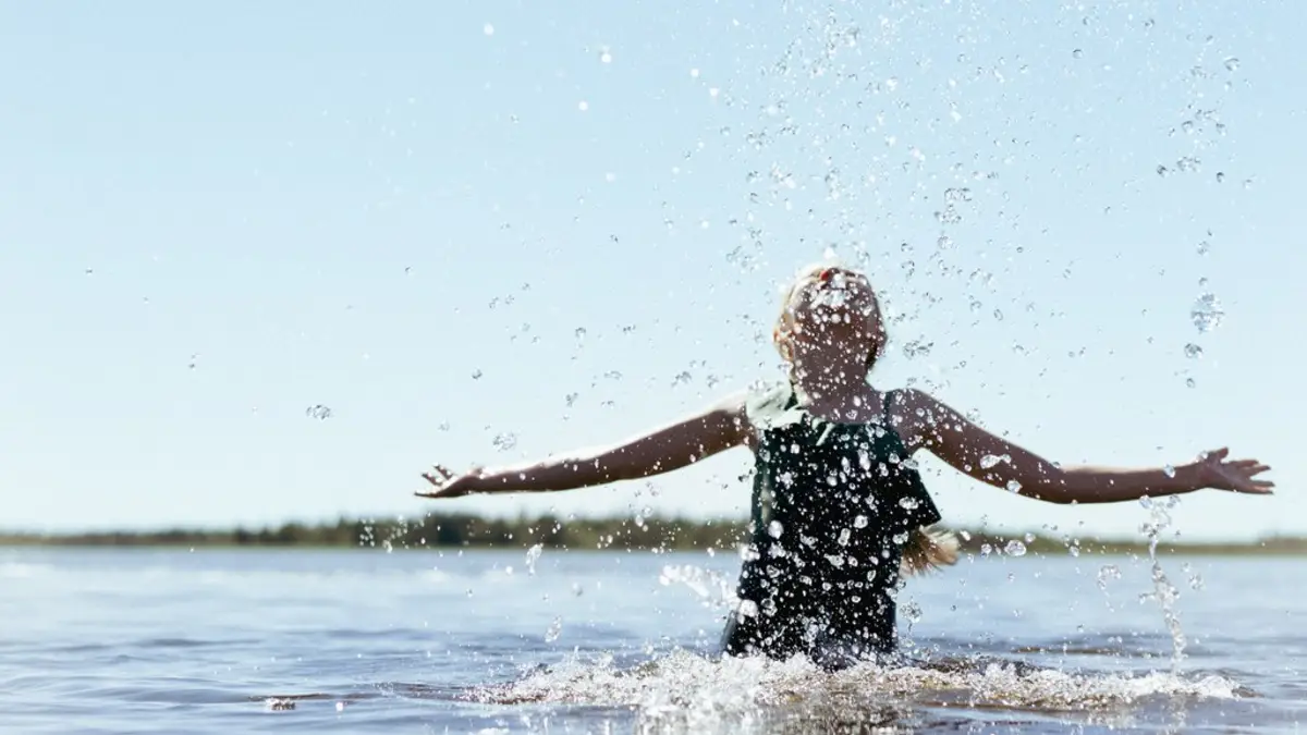 Child enjoying a sunny summer day at Äkäslompolo beach in Ylläs, Lapland