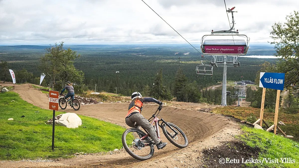 Riders enjoying downhill biking at Ylläs Bike Park in Lapland with gondola lift and fell views in summer