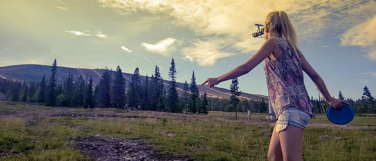 Playing frisbee golf in Äkäslompolo during a sunny summer evening with Ylläs fell scenery in Lapland