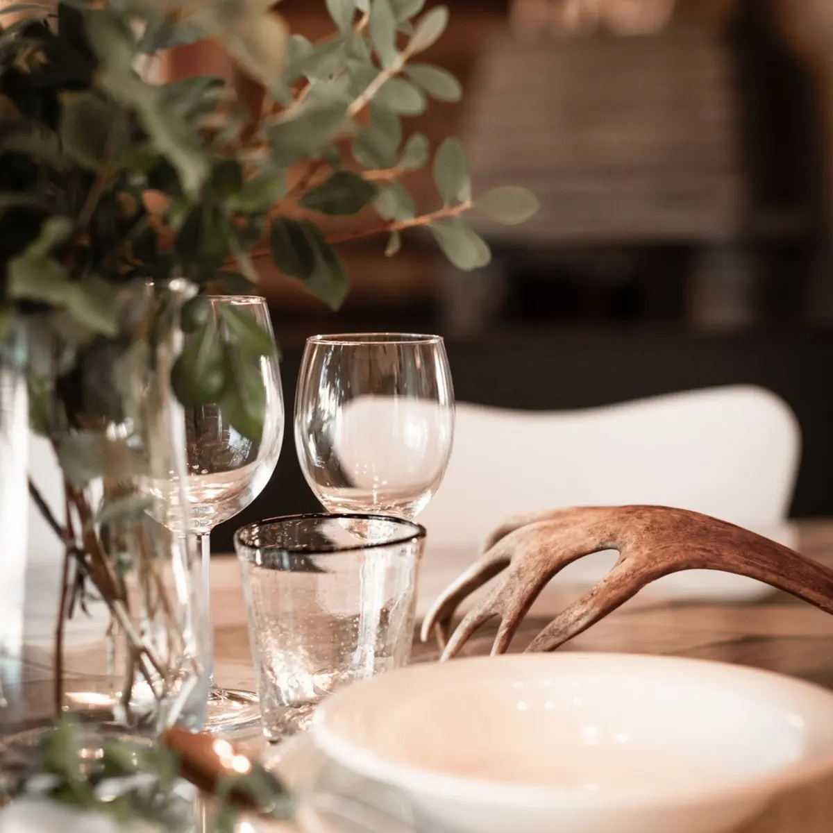 Cozy dinner setting at a cabin in Lapland with wine glasses and warm evening atmosphere