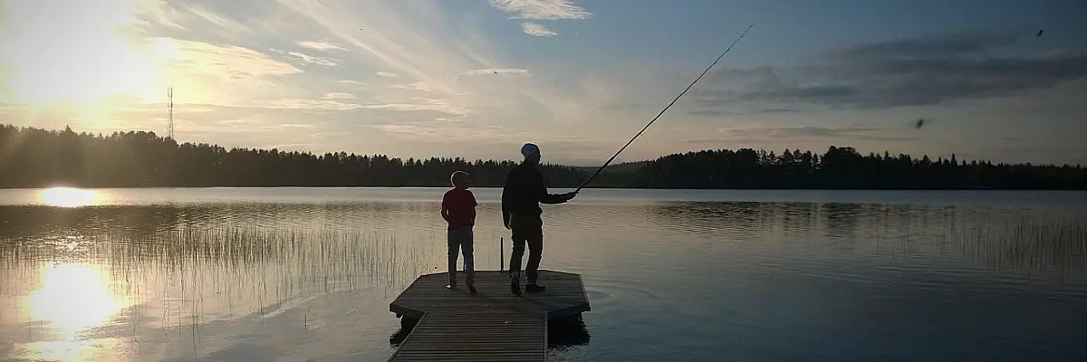 Peaceful evening fishing on a lake in Ylläs, Lapland during the bright summer night