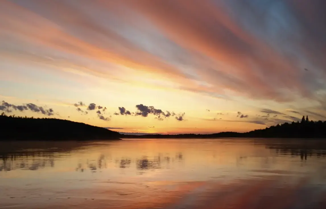 Peaceful summer evening in Ylläs, Lapland with colorful sunset reflections over a calm lake