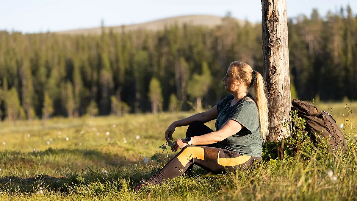 Woman enjoying a light morning hike in Ylläs, Lapland surrounded by peaceful summer fell scenery